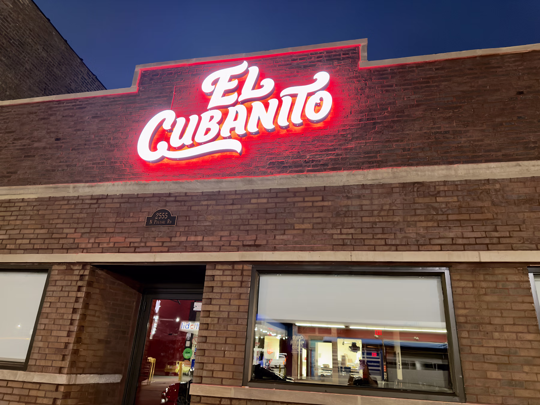 Custom flush-mounted channel letters with white front-lit faces and red halo-lit LED illumination on brick facade at El Cubanito restaurant.