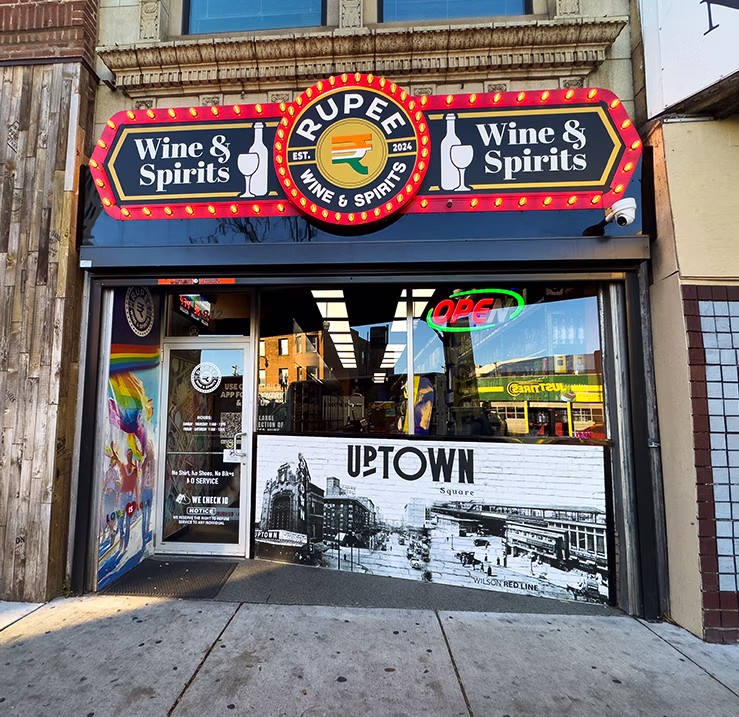 Rupee Wine & Spirits storefront in Chicago featuring custom illuminated marquee signage and Uptown window graphics.